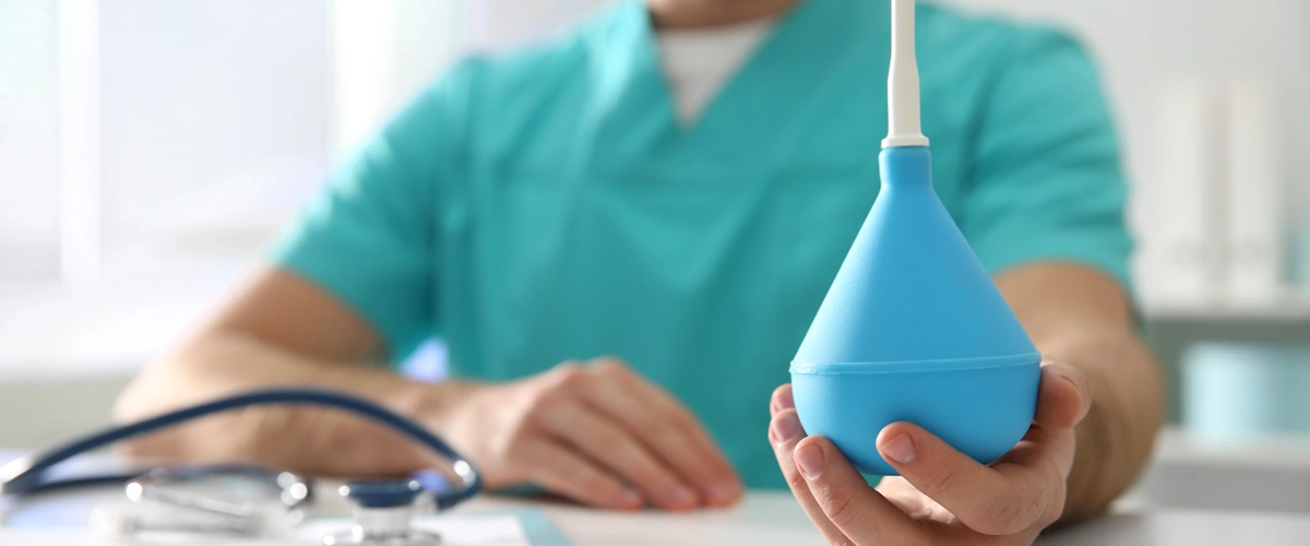 Infermiera che prepara un clistere evacuativo